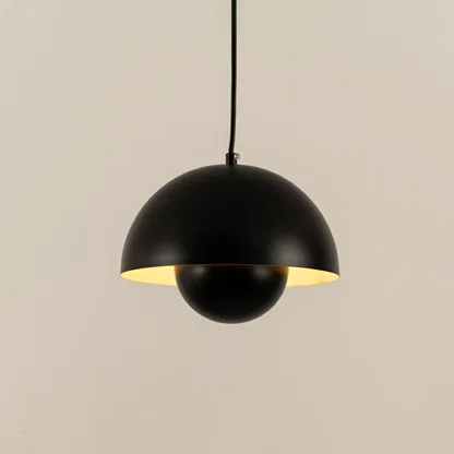 Illuminated black metal pendant light with layered shade creating warm ambient lighting indoors.