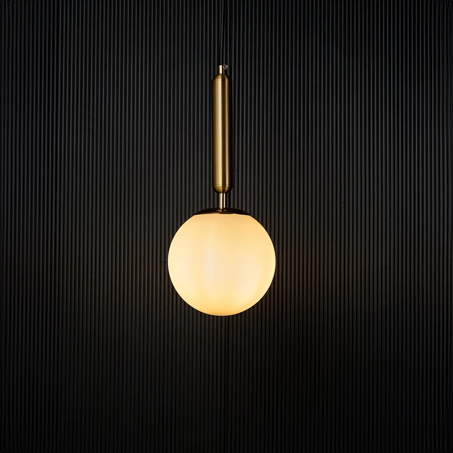 Modern pendant light glowing warmly against a dark background creating a striking contrast that highlights its elegant gold and white finish.