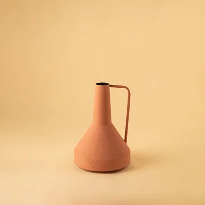 Cream colored ceramic pitcher with minimalist design and angular metal handle perfect for contemporary home decor and flower arrangements.
