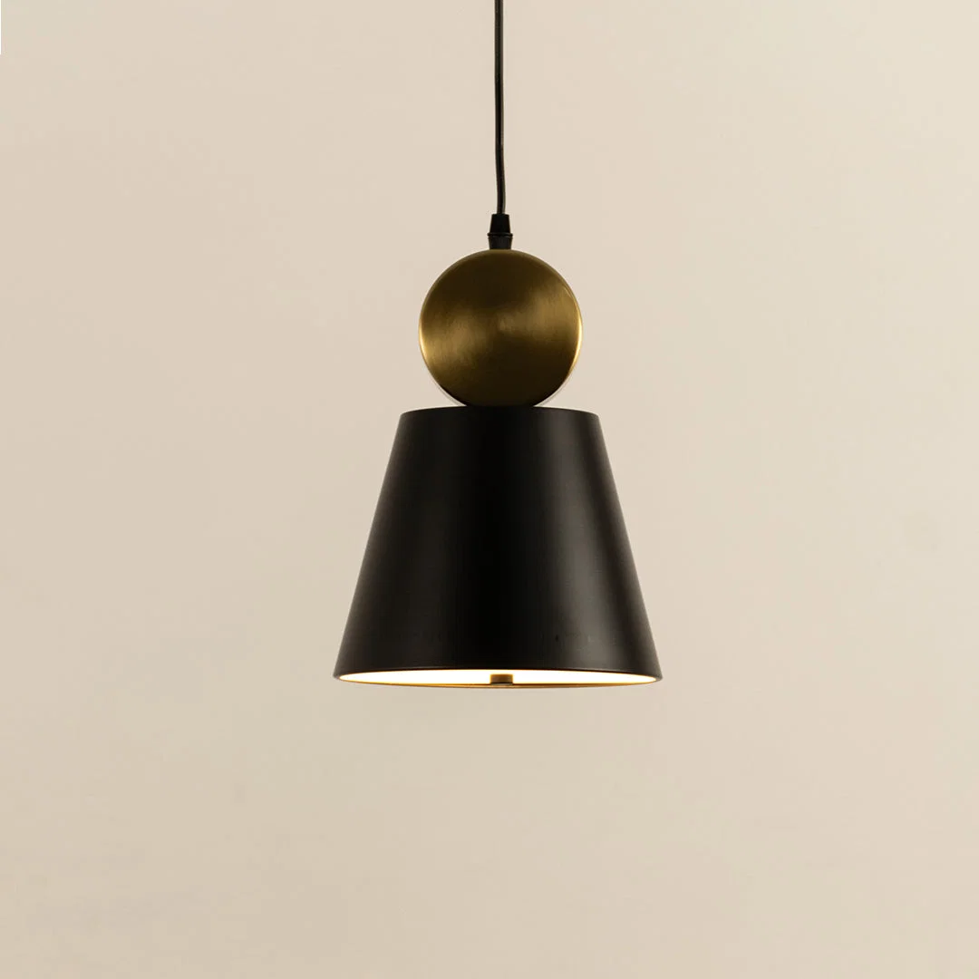 Closeup of black metal pendant light with gold top accent showing minimal cone design and smooth finish for modern interior decor.