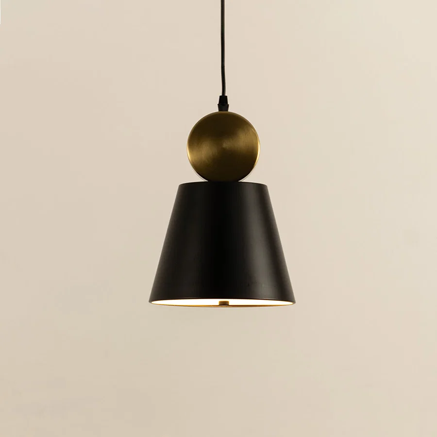Closeup of black metal pendant light with gold top accent showing minimal cone design and smooth finish for modern interior decor.