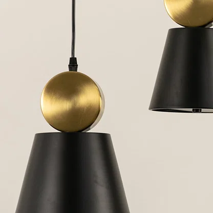 Black metal pendant light with gold sphere accent closeup highlighting premium craftsmanship and modern design.