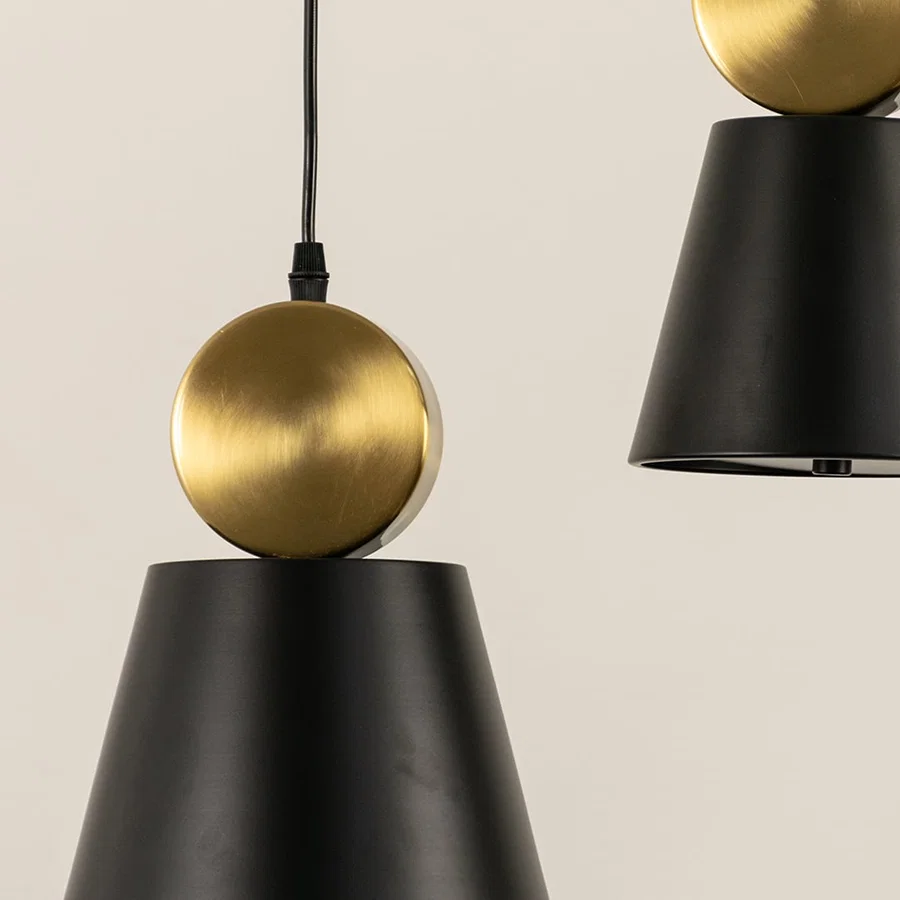 Black metal pendant light with gold sphere accent closeup highlighting premium craftsmanship and modern design.
