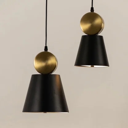 Black and gold metal pendant lights illuminated to display contemporary decorative ceiling lighting with elegant styling.
