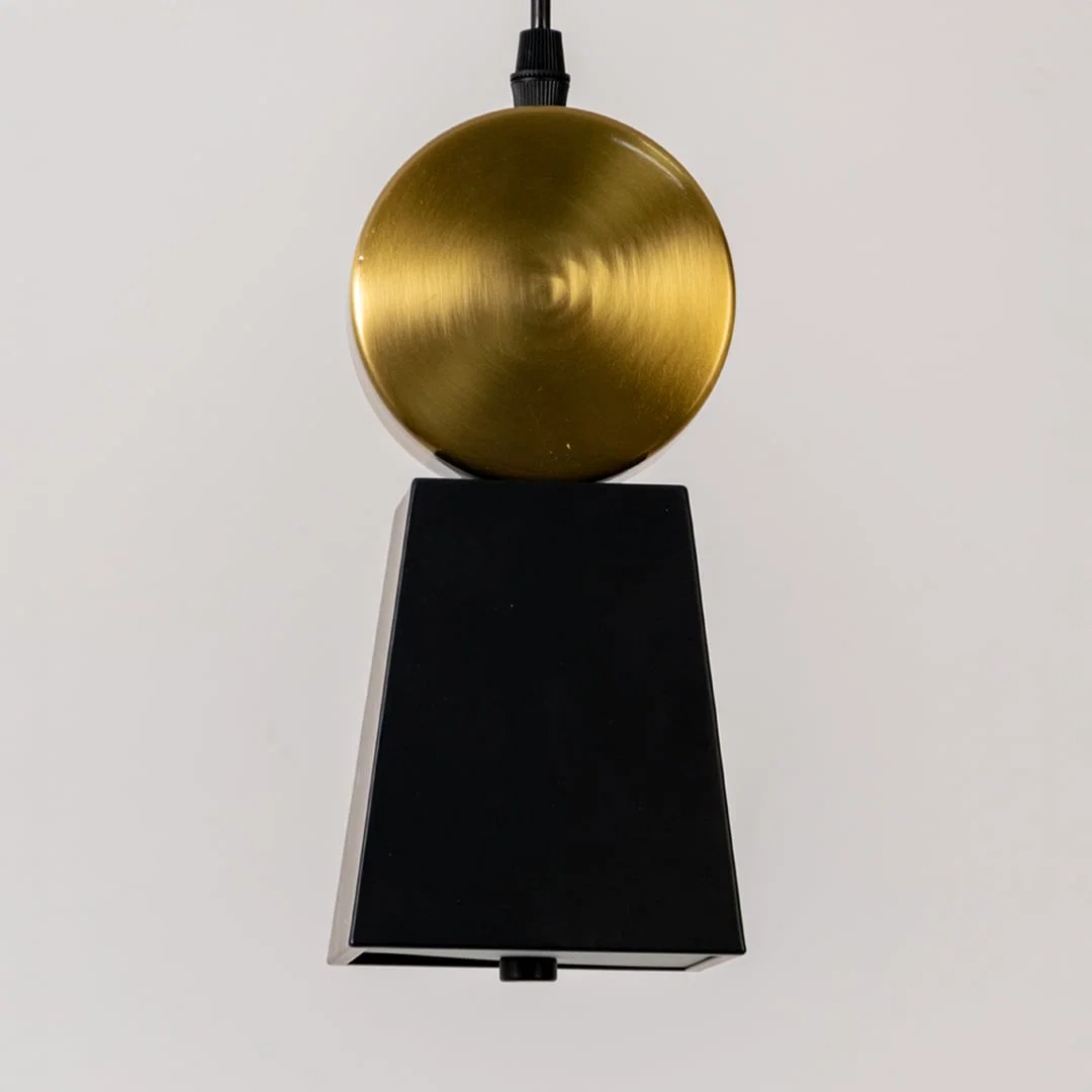 Black metal pendant light with gold sphere accent illuminated to showcase luxury modern ceiling lighting.