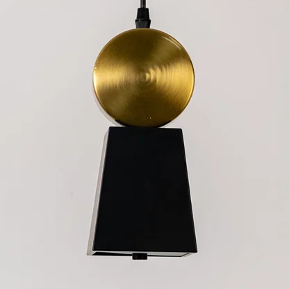Black metal pendant light with gold sphere accent illuminated to showcase luxury modern ceiling lighting.