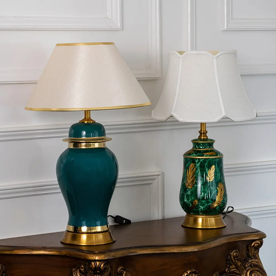 Green ceramic lamps with golden bases and white fabric shades turned off arranged in grouped setup.
