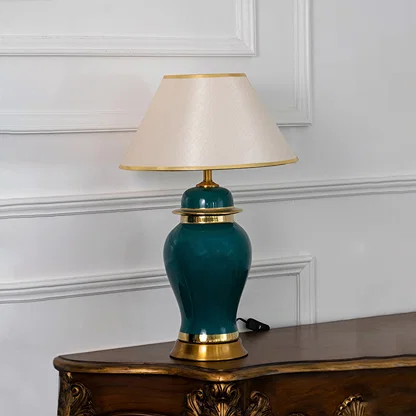 Teal ceramic table lamp with fabric shade and gold accents creating refined traditional lighting for elegant home interiors.