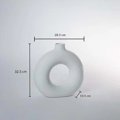 White ceramic donut vase 32.5cm height 28.5cm width and 10.5cm depth shown on white background with measurement scale.
