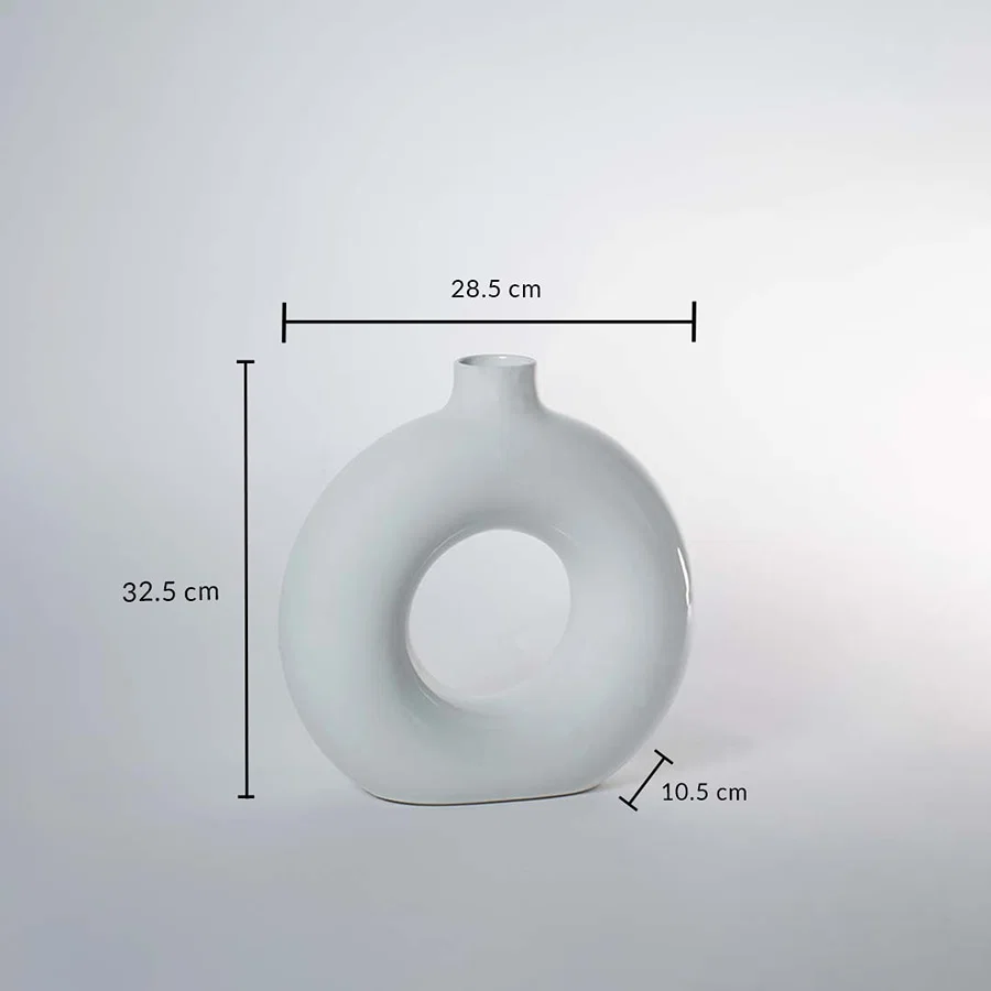 White ceramic donut vase 32.5cm height 28.5cm width and 10.5cm depth shown on white background with measurement scale.