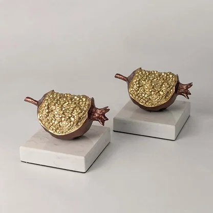 Set of gold and brown decorative pomegranate sculptures for elegant shelf styling and luxury home decor displays.