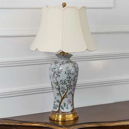 Unlit floral ceramic table lamp with gold metal base and cream shade radiates artistic charm and elegance as a decor piece even when not in use.