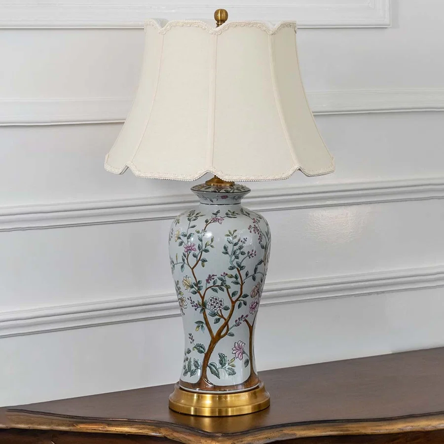 Unlit floral ceramic table lamp with gold metal base and cream shade radiates artistic charm and elegance as a decor piece even when not in use.