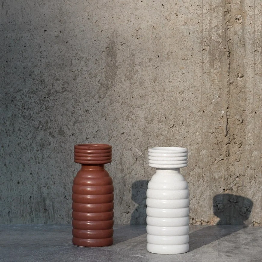 Grouped image showcasing the ribbed white ceramic vase in a clean minimal setup  highlighting its modern shape and textured design.