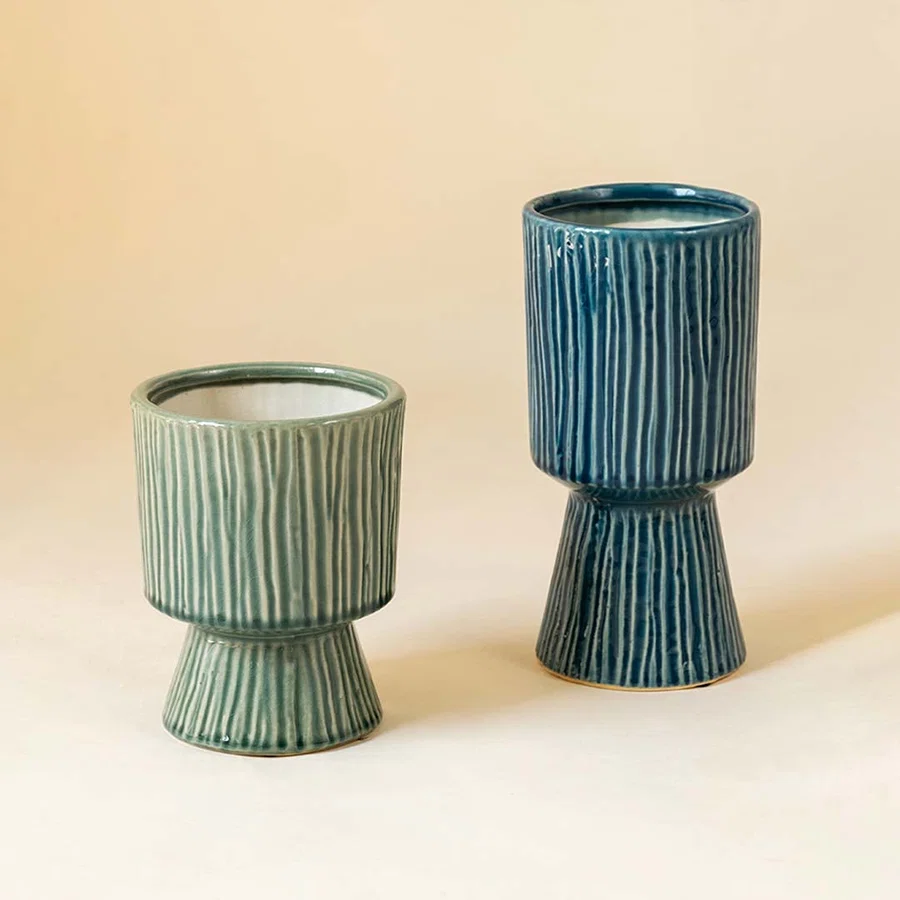Collection of green ribbed ceramic vases in varying sizes displayed together for coordinated contemporary home decor.