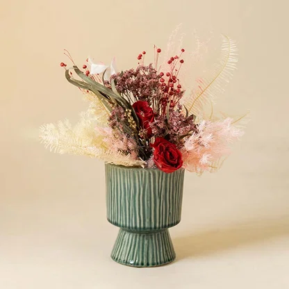 Stylish ribbed green ceramic vase placed in bright interior setup adding artistic charm to modern home styling.