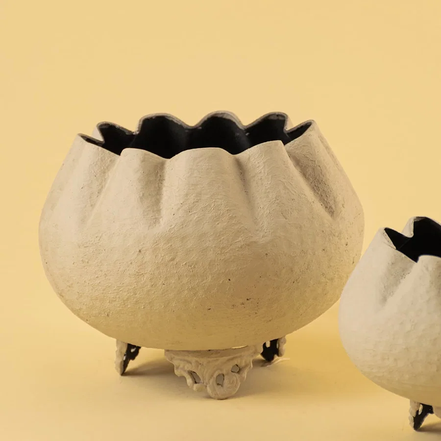 Closeup of cream metal scalloped bowl planter showing textured surface and ornate base perfect for elegant home styling.