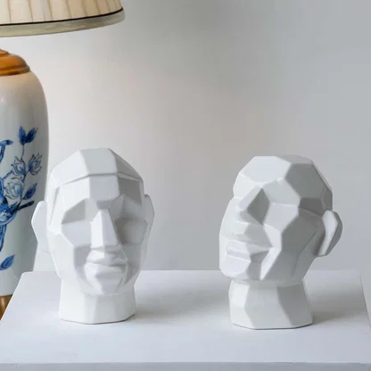 Pair of white geometric head sculptures with faceted surfaces perfect for minimalist modern interior styling.
