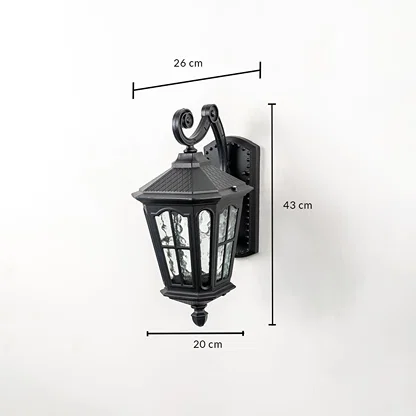 Outdoor wall light with ornate lantern design black frame and glass panels shown with 43 cm height 26 cm width 20 cm depth.