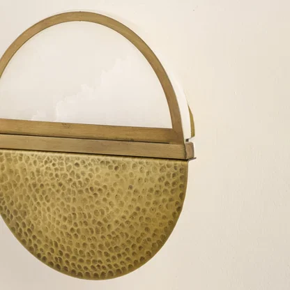 Closeup of textured gold metal wall light for elegant hallway and contemporary decor styling spaces.

