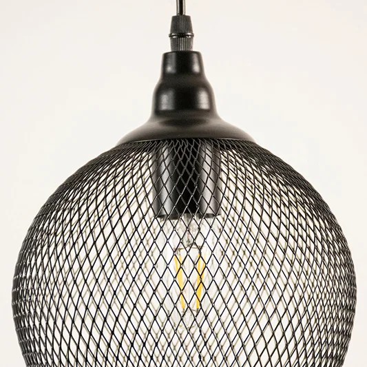 Black metal mesh pendant light closeup highlighting intricate wire detailing and industrial lighting craftsmanship.