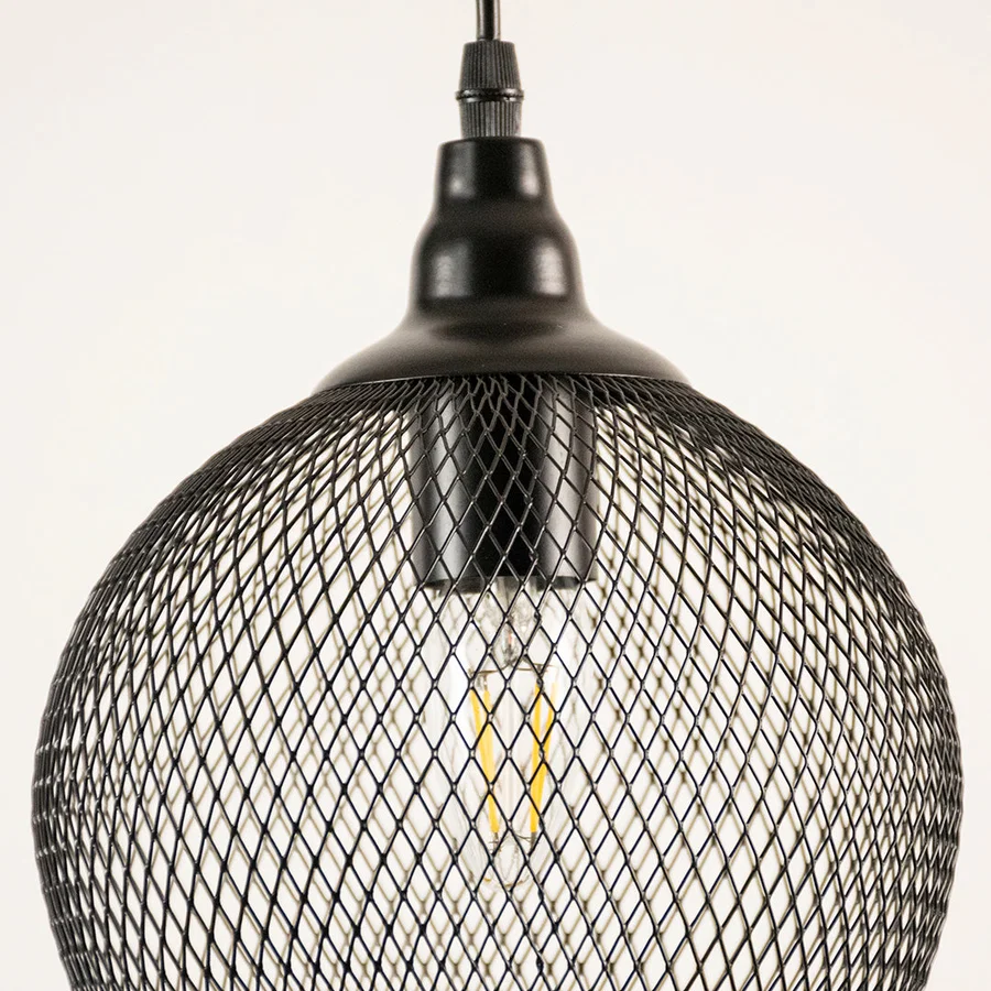 Black metal mesh pendant light closeup highlighting intricate wire detailing and industrial lighting craftsmanship.