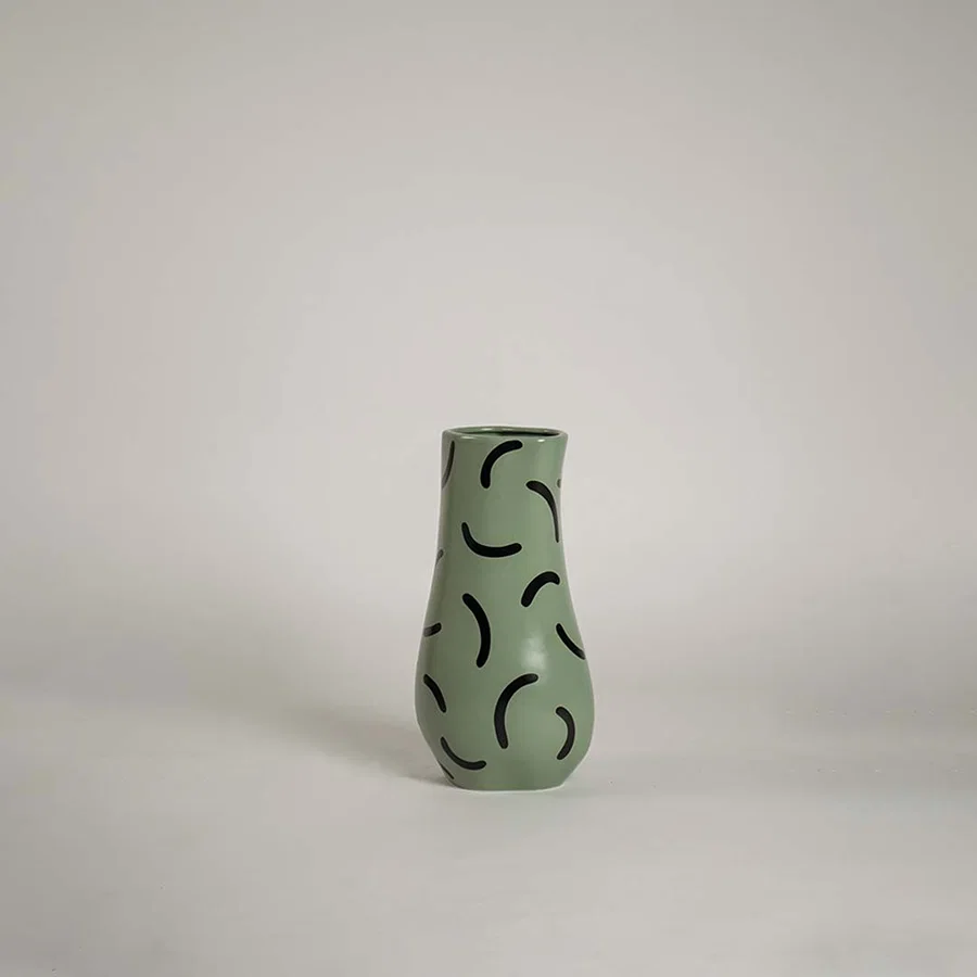 Sage green ceramic bud vase featuring abstract black squiggly line patterns on white background for modern playful art.