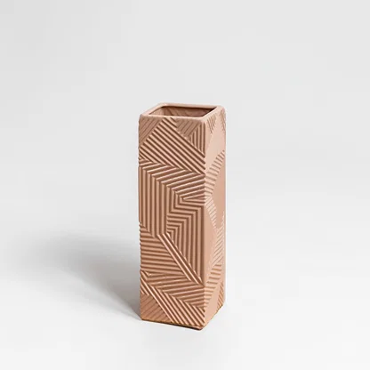 Beige ceramic decorative vase with geometric carved pattern for shelf styling and contemporary home decor displays.