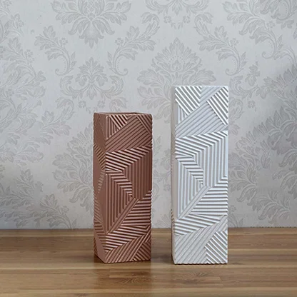 Set of white ceramic vases with geometric embossed patterns arranged together for a coordinated modern home decor display.