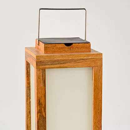 Closeup of wooden lantern with frosted glass panels and metal handle for rustic decor styling use.