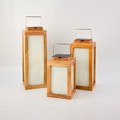 Set of three wooden lanterns in various sizes placed together perfect for indoor and outdoor decorative lighting — an elegant home styling accessory.