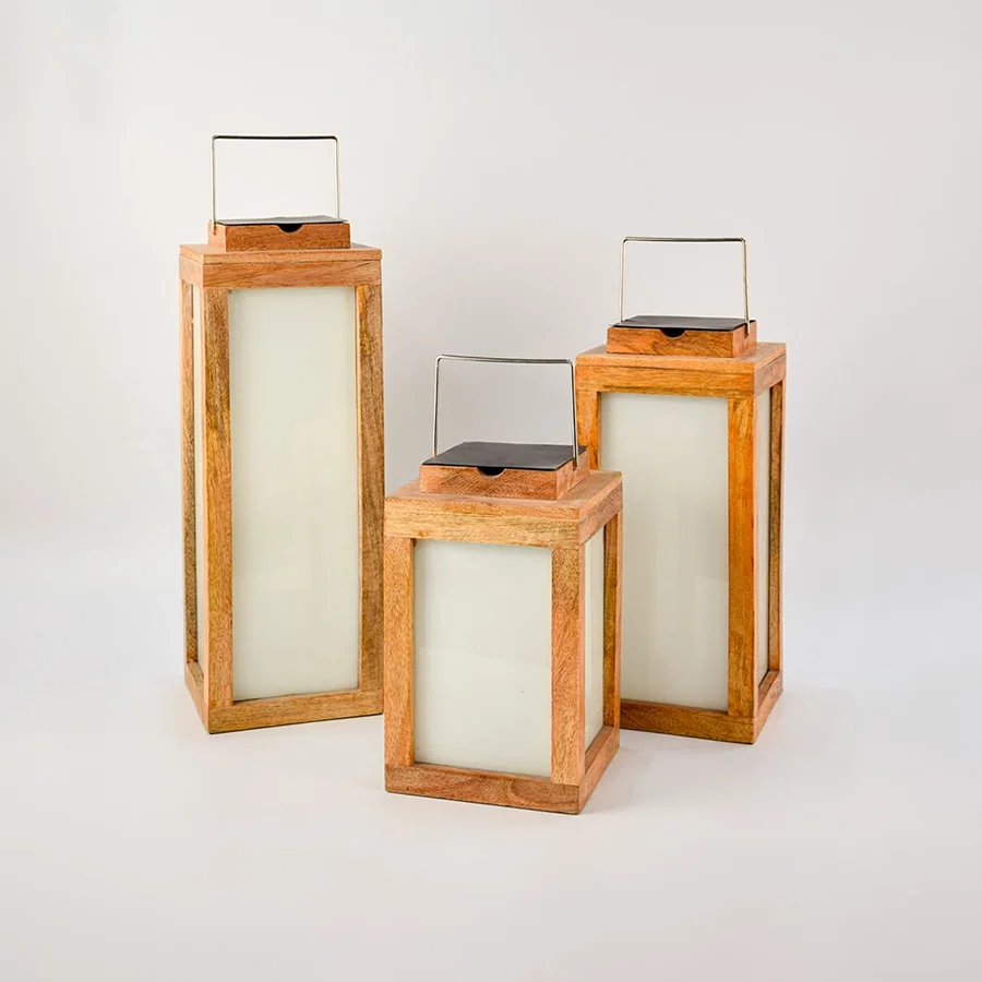 Set of three wooden lanterns in various sizes placed together perfect for indoor and outdoor decorative lighting — an elegant home styling accessory.