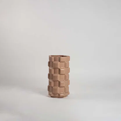 Natural beige ceramic decorative vase with stacked geometric design for modern shelf styling and home decor display.