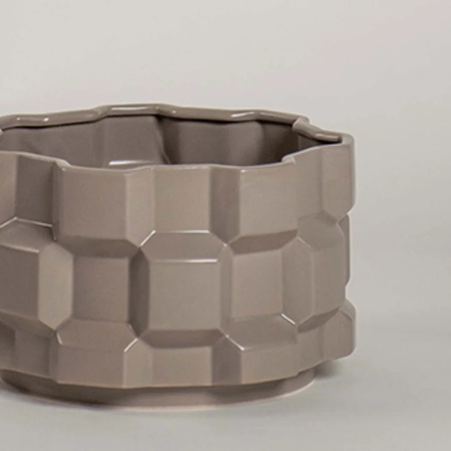 Closeup view of the taupe geometric ceramic planter highlighting the textured pattern and smooth ceramic finish.