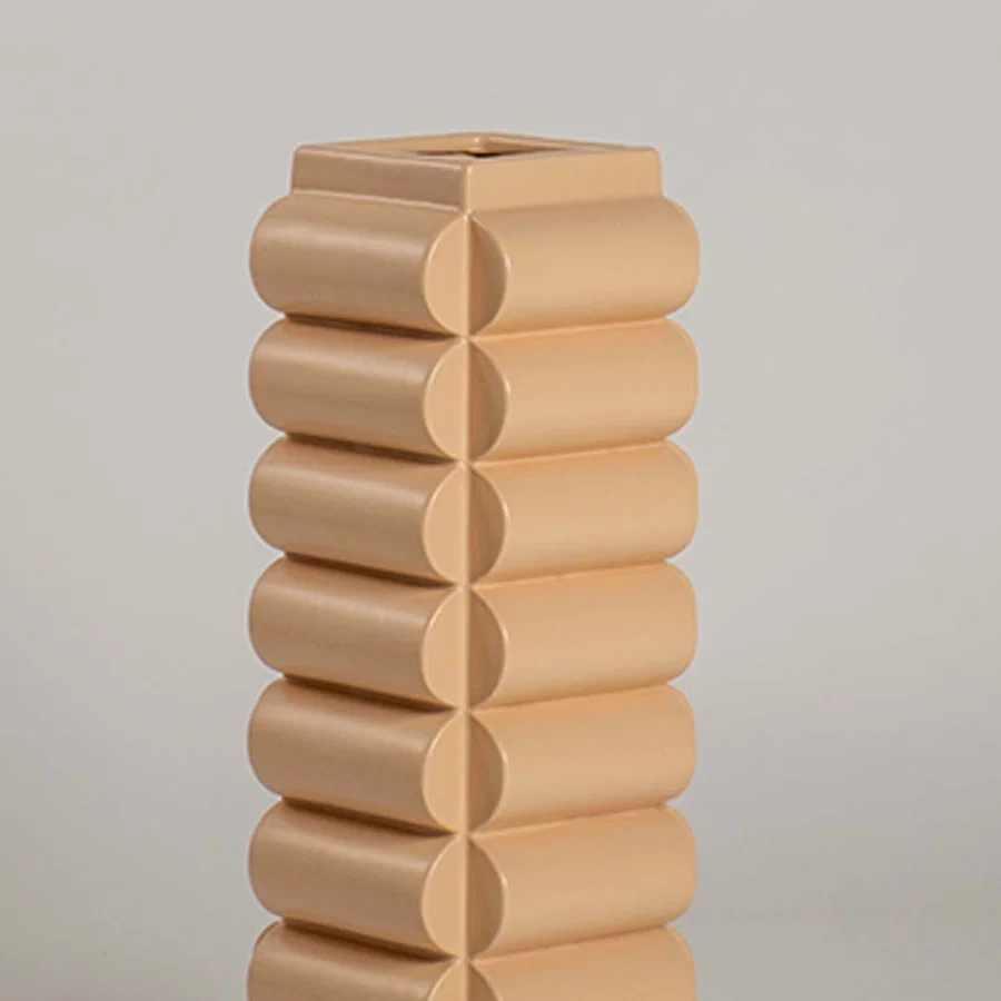 A detailed closeup of the beige geometric vase showing its rounded stacked pattern and smooth finish highlighting its modern artistic design.