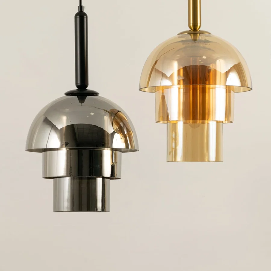 Chrome and amber glass pendant lights illuminated to highlight contemporary decorative ceiling lighting craftsmanship.