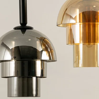 Chrome and amber glass pendant lights closeup showcasing reflective finishes and premium lighting craftsmanship quality.