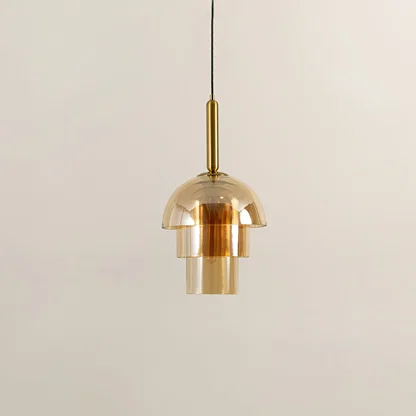 Amber glass pendant light with gold metal fixture illuminated to display premium modern ceiling lighting appeal.