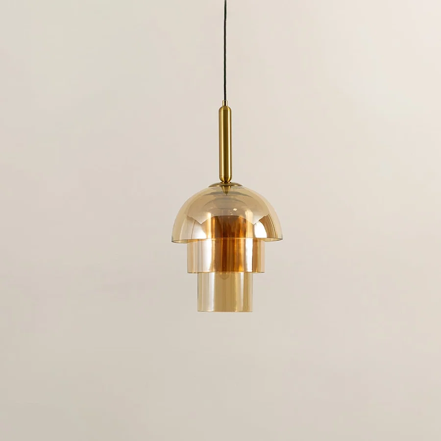 Amber glass pendant light with gold metal fixture illuminated to display premium modern ceiling lighting appeal.