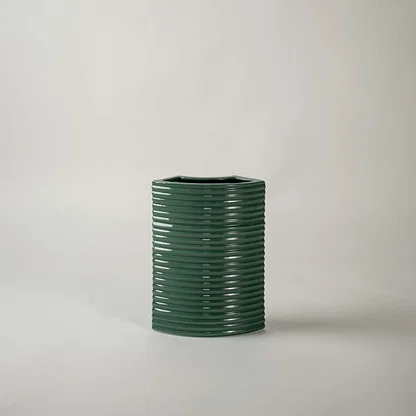 Green ribbed ceramic decorative vase with cylindrical silhouette for tabletop styling and modern home decor display.