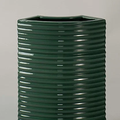 Closeup of dark green ribbed ceramic planter showing glossy textured detailing ideal for modern minimal home styling.