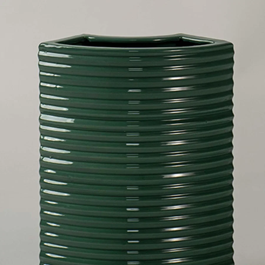 Closeup of dark green ribbed ceramic planter showing glossy textured detailing ideal for modern minimal home styling.
