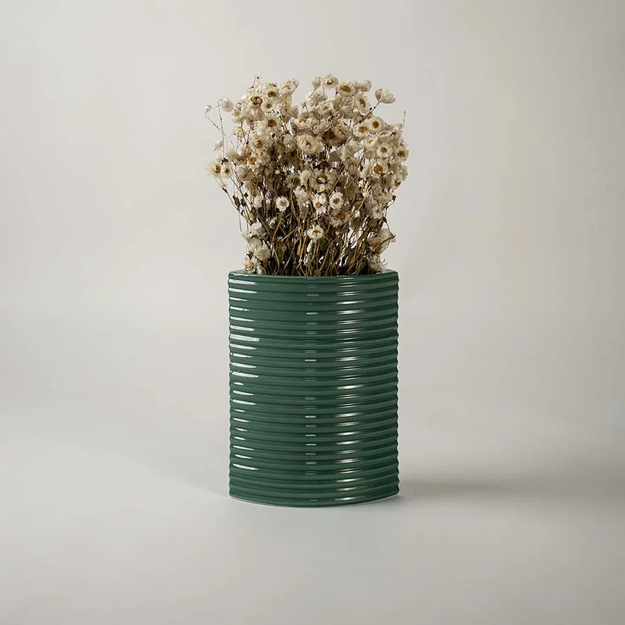 Tall dark green ceramic planter placed in a stylish interior setting perfect for living rooms hallways and modern decor accents.