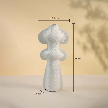 White sculptural vase displayed on a neutral surface measuring 36 cm in height and 17 cm in width with a 7 cm base.