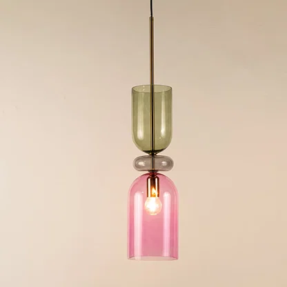 Green and pink glass pendant light with metal frame illuminated to highlight modern decorative ceiling lighting.
