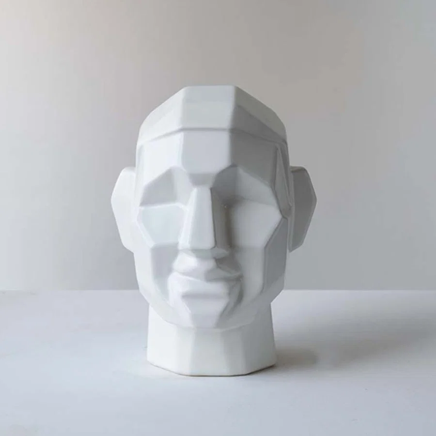 White ceramic decorative face sculpture with faceted geometric detailing for contemporary home decor displays.