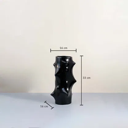 Black sculptural ceramic vase with glossy finish showing 33 cm height and 16 cm width with dimension guide on plain background.