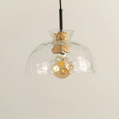 Clear wavy glass and brass metal pendant light designed for stylish dining room decor spaces.