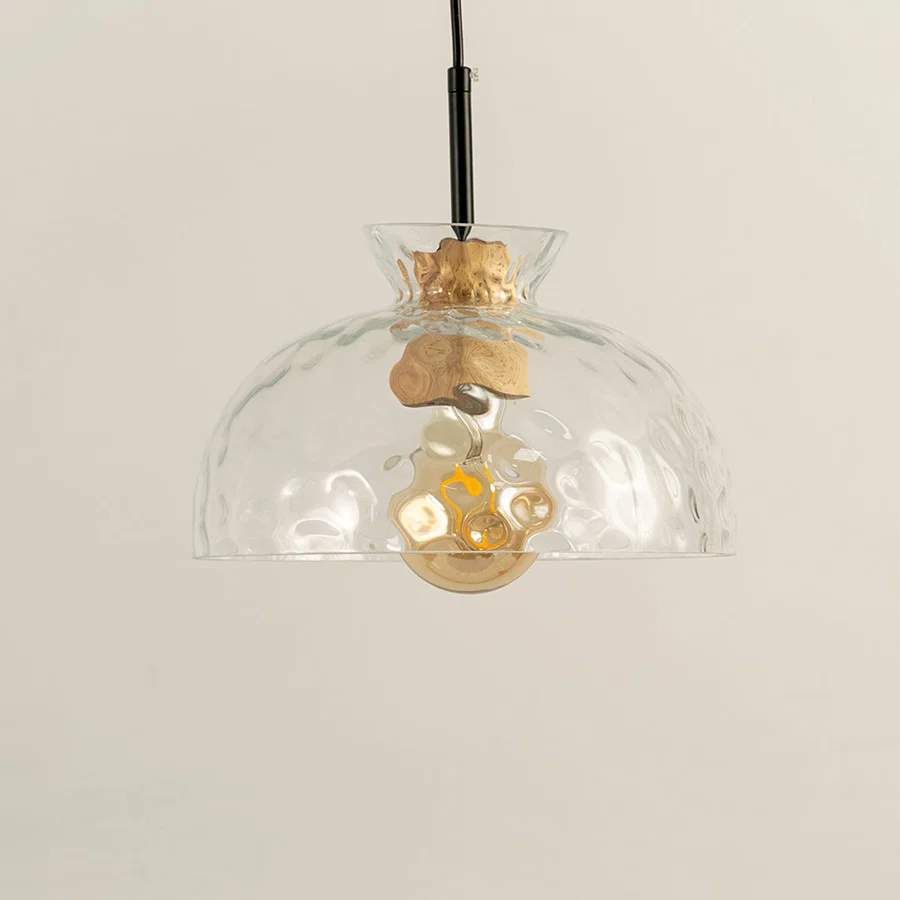 Clear wavy glass and brass metal pendant light designed for stylish dining room decor spaces.