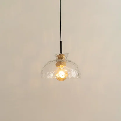 Clear sculpted glass and brass metal pendant light with warm glow for elegant modern interiors.